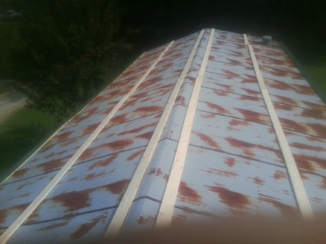 Rusted metal roof panels with new wood purlins before replacement — Storm Damage Roof Repair in Four Oaks by Roofing Brothers