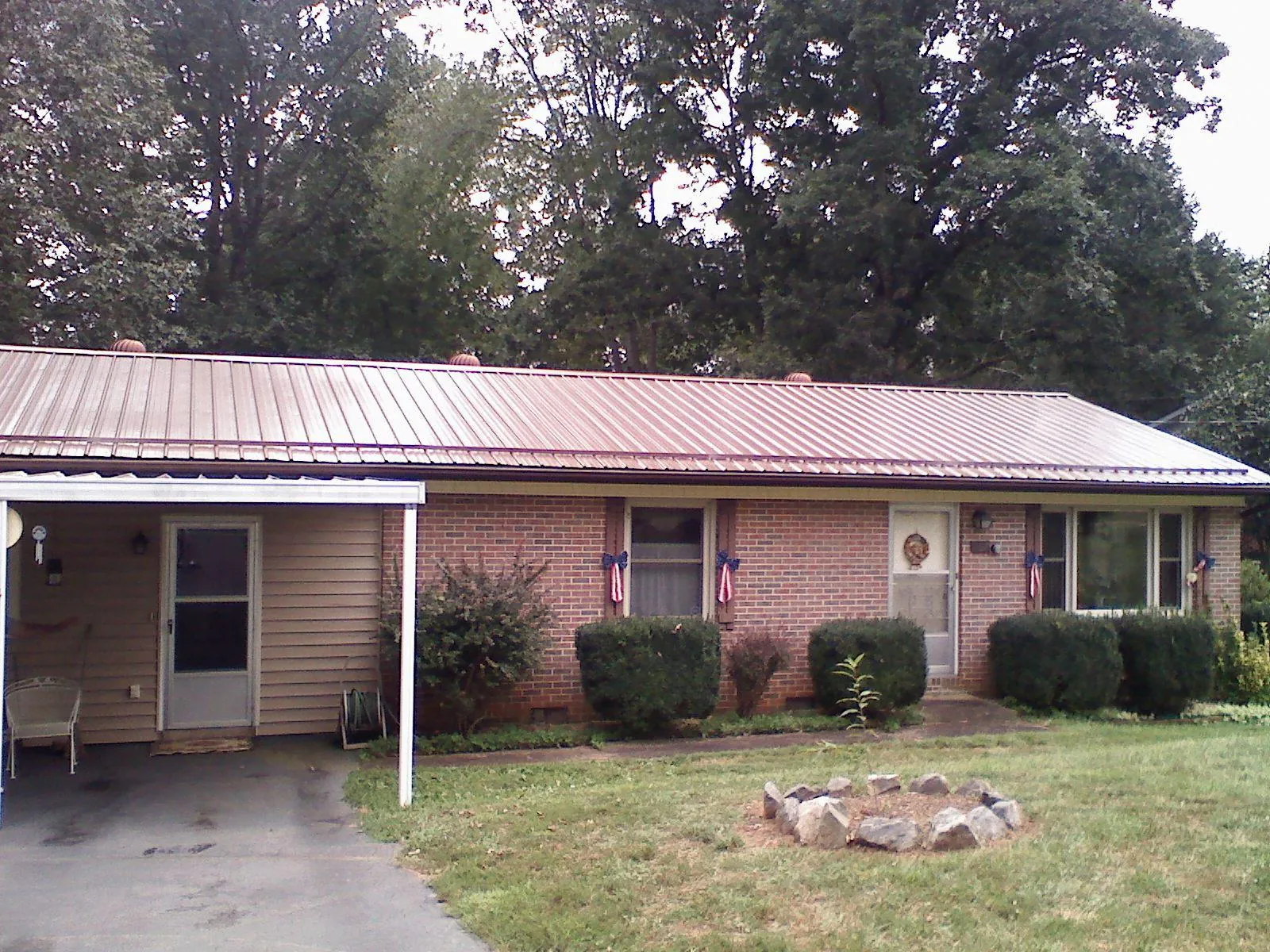 Bronze metal roof and carport on a brick ranch home — Roof Repair work by our crew in Four Oaks