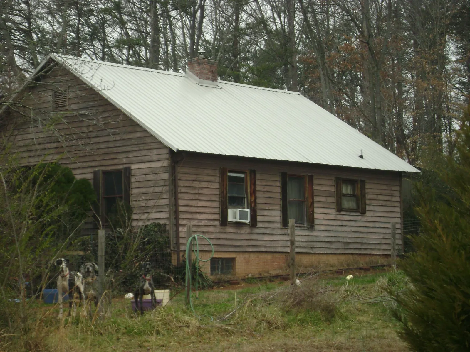White metal roof on an old wood sided farmhouse, from a Metal Roof Installation job in Four Oaks